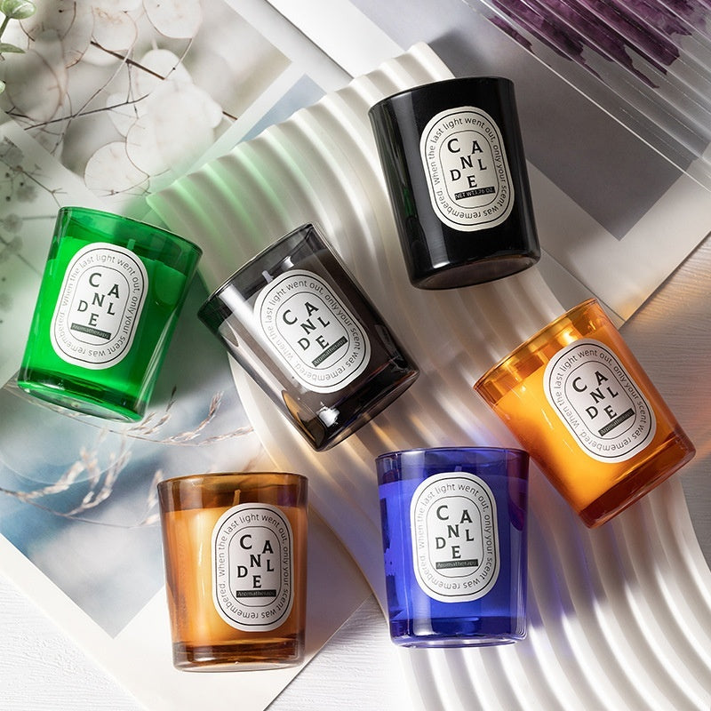 A collection of Delphy Candle scented candles in vibrant rainbow glass jars, arranged on a stylish surface for a cozy, aesthetic home decor display.