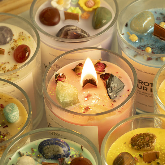 A full lineup of cylindrical crystal candles in blue, white, green, yellow, purple, pink, and orange.