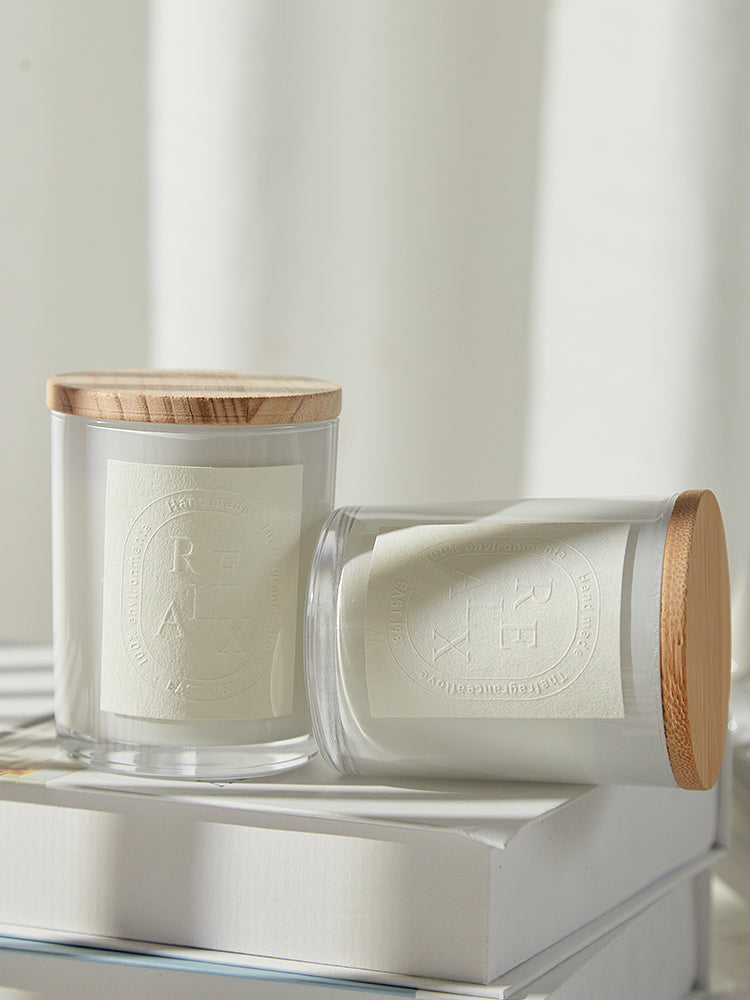 Elegant glass jar candles in different scents like Sandalwood and Misty Forest arranged on a vanity.