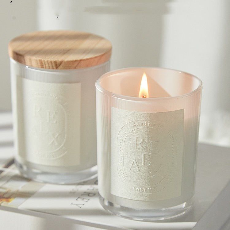Lit Essential Oil Osmanthus Candle in frosted glass creating a warm and cozy winter atmosphere.