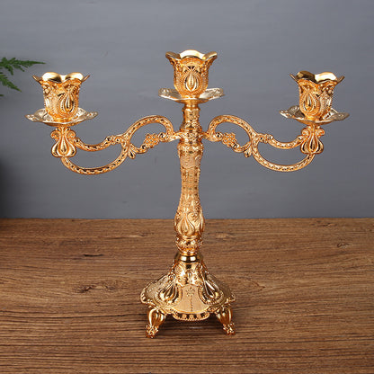 Three-arm gold tulip candle holder with decorative landscape flower patterns, ideal for fireplace mantel decor.
