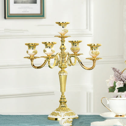 A luxurious goldenwhite 5-arm zinc alloy candelabra with intricate floral embossed patterns on a wooden surface.