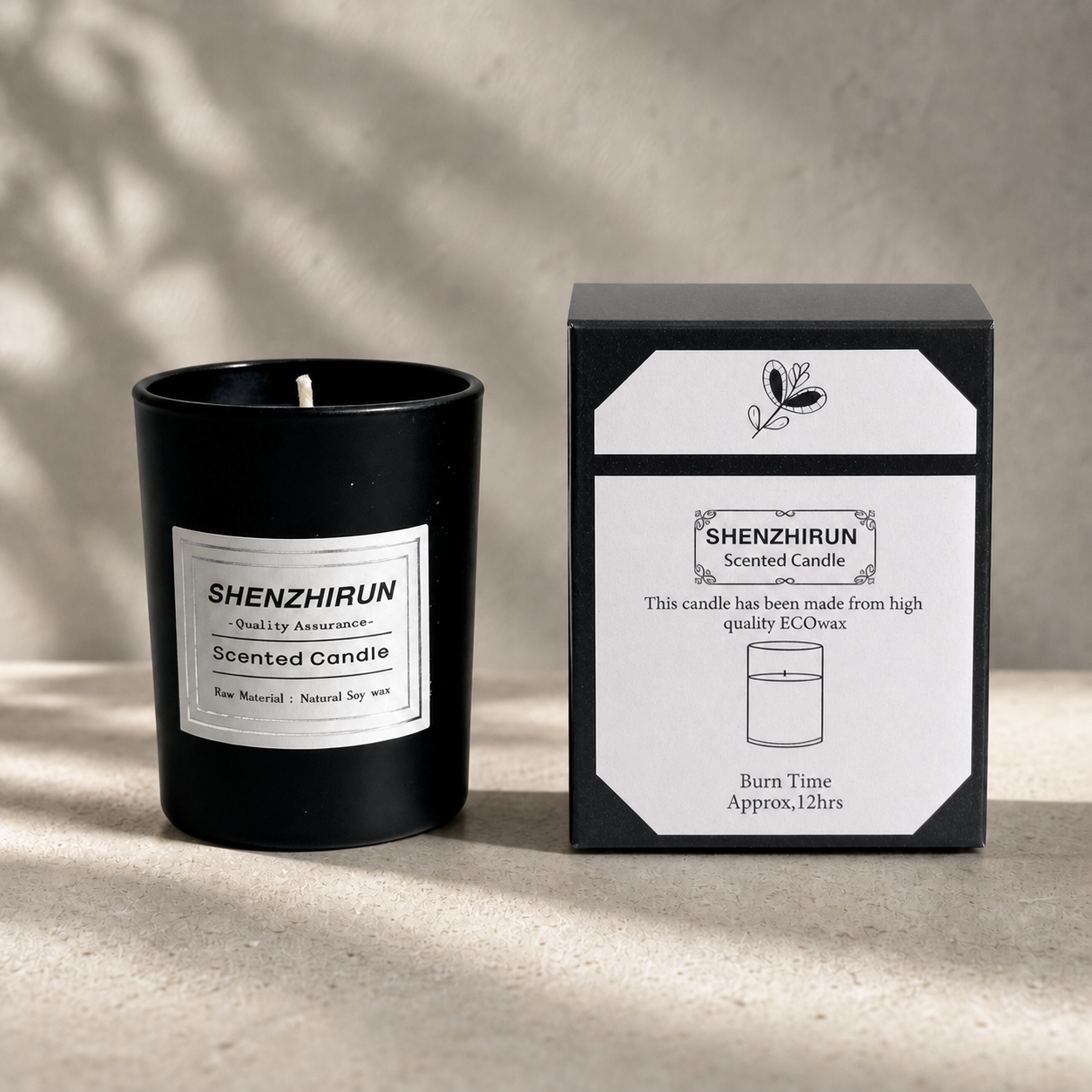 Black frosted Stress Relief Soy Candle in the small six by five centimetre cup beside its twelve hour packaging.